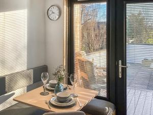 a table with wine glasses and a clock on the wall at Wee Shore Walk in Balintore