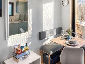 a small dining room with a table and a kitchen at Wee Shore Walk in Balintore