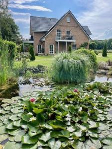 a house with a pond with lilies in front of it at Borby-EG-Nr-2 in Haby