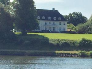 a large white house next to a body of water at Borby-EG-Nr-2 in Haby +36 photos