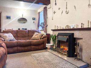 a living room with a couch and a fireplace at Blindbeck Holiday Cottage in Settle