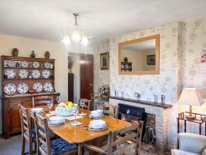 a dining room with a table and a fireplace at Blindbeck Holiday Cottage in Settle +29 photos