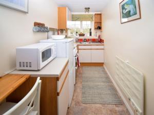 a small kitchen with a microwave on a counter at The Barley Mow in Kirkoswald