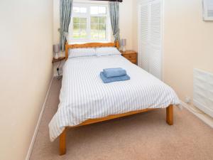 a bedroom with a bed with a blue towel on it at The Barley Mow in Kirkoswald