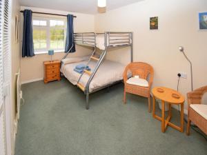 a bedroom with a bunk bed and a table and a chair at The Barley Mow in Kirkoswald