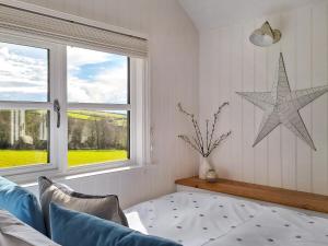 a living room with a couch and a star on the wall at Pip's Hut in Bideford +25 photos
