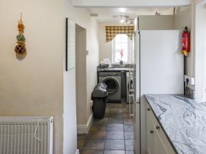 a kitchen with a washer and dryer in a room at The Cottage in Broad Haven