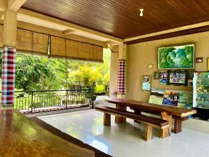 a wooden bench in a room with a balcony at Guesthouse Gusti Putu Oka in Ubud