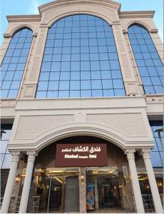 a tall building with a sign in front of it at فندق الكشاف المتقدم توصيل للحرم مجاني in Mecca