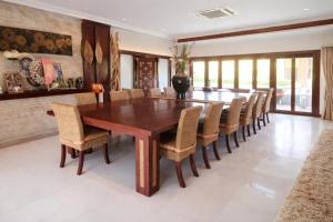 a dining room with a wooden table and chairs at Baan Katthaliya in Hua Hin