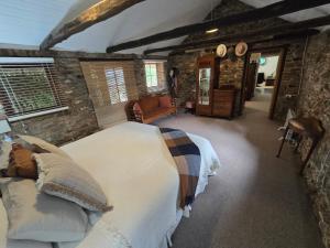 a bedroom with a large bed and a stone wall at Tara Stables in Littlehampton