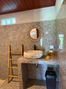 a bathroom with a stone sink and a mirror at Lumbung Intan in Sidemen
