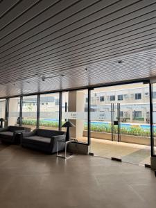 a lobby with couches in a building with windows at Blanc Suite in Dasmariñas