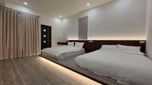 a bedroom with two beds and a large window at Fu Qiaoqing Travel電梯獨棟 in Wujie