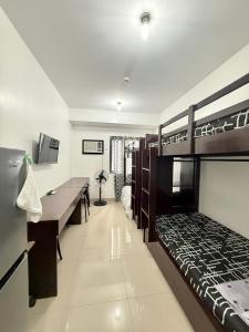a bedroom with two bunk beds and a desk at Blanc Suite in Dasmariñas