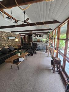 a living room with couches and tables and windows at Tara Stables in Littlehampton