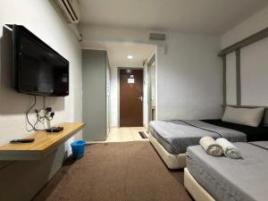 a bedroom with two beds and a flat screen tv at MyPlace Sri Cemerlang Kota Bharu in Kota Bharu