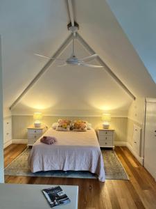 a bedroom with a white bed with two night stands at The Haven Cottage Point Sydney in Cowan