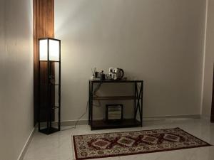 a room with a table and a rug and a lamp at روڤان in Hafr Al-Batin