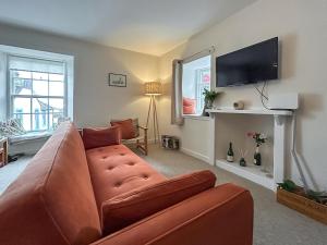 a living room with a couch and a flat screen tv at Sea View Apartment in Anstruther
