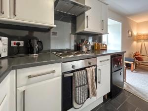 a kitchen with white cabinets and stainless steel appliances at Sea View Apartment in Anstruther
