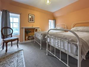 a bedroom with two bunk beds and a chair at Sea View Apartment in Anstruther +6 photos