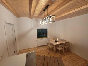 a dining room with a table and a tv at La casa morarului in Cârțișoara