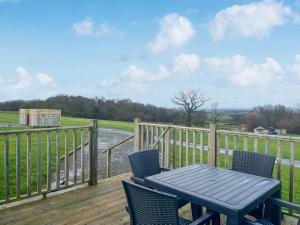 a table and chairs on a deck with a view of a river at Oak Tree Lodge - Uk51429 in Westward
