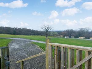 a wooden fence next to a road in a field at Oak Tree Lodge - Uk51429 in Westward
