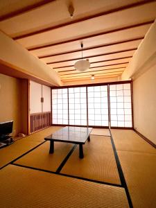 ein Raum mit einem Tisch in der Mitte in der Unterkunft Hotel Kodama in Yamanouchi