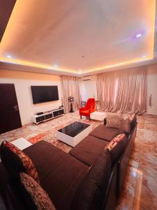 a living room with a couch and a tv at Liberty Suite - Abuja in Abuja