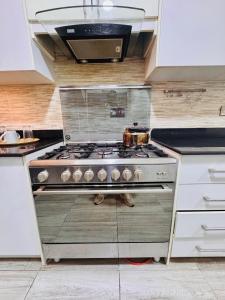 a kitchen with a stove with a pot on it at Liberty Suite - Abuja in Abuja