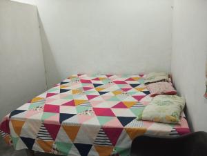 a bedroom with a colorful quilt on a bed at ram sadan in Ayodhya +20 photos