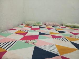 a bed with a colorful quilt and pillows on it at ram sadan in Ayodhya