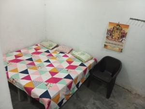 a small bedroom with a bed and a chair at ram sadan in Ayodhya