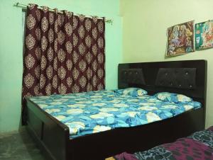 a bed with a blue comforter in a bedroom at ram sadan in Ayodhya