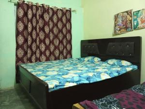 a bed with a blue comforter in a bedroom at ram sadan in Ayodhya