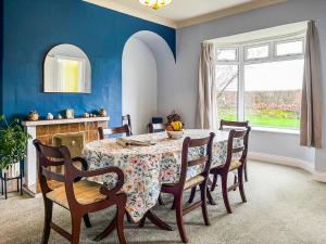 a dining room with a table and chairs and a window at Paddock Cottage in Morpeth