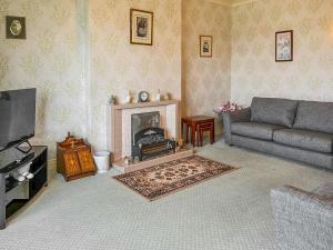 a living room with a couch and a fireplace at Paddock Cottage in Morpeth
