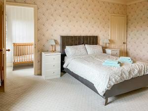a bedroom with a bed and two lamps and a window at Paddock Cottage in Morpeth +6 photos