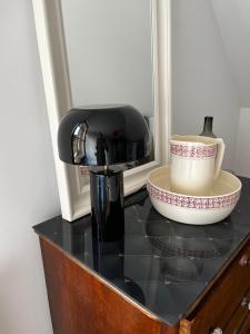 a black counter top with a coffee maker and a bowl at Allgäu Cottage - traumhafter Blick in die Schweizer Berge in Weiler-Simmerberg +41 photos