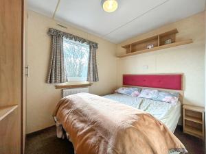 a small bedroom with a bed and a window at Wah Caravan in Dundee