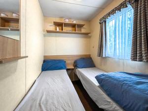two beds in a small room with a window at Wah Caravan in Dundee