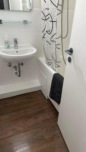 a bathroom with a sink and a shower curtain at FeWo am Deich 4 in Bremerhaven