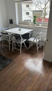 a white table and chairs in a room with a window at FeWo am Deich 4 in Bremerhaven