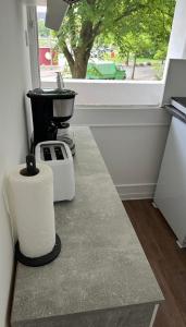 a kitchen counter with a sink and a window at FeWo am Deich 4 in Bremerhaven +6 photos