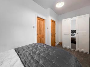 a white bedroom with a bed and a closet at Old Steamship Quarters in Whitby +9 photos