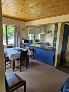 a kitchen and dining room with a table and chairs at Estuary Hideaway in Whangamata