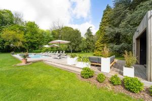 a backyard with a swimming pool and a lawn at La Château de Toile, Gîte du Marronnier in Hersin-Coupigny