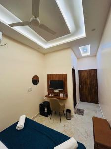 a bedroom with a bed and a desk and a tv at Hotel DVL INN- Near Jalmahal Jaipur in Jaipur +27 photos